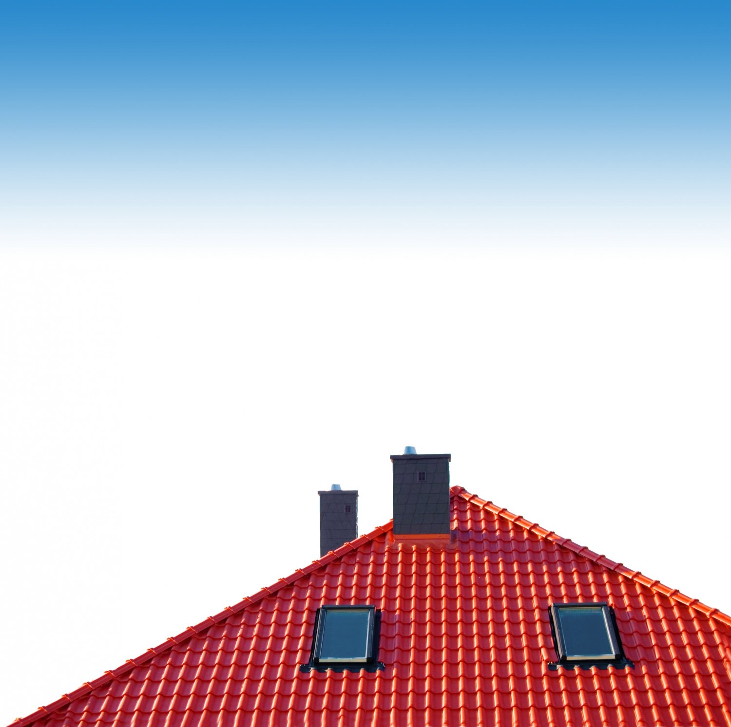 Red tiled roof with two skylights and three chimneys against a clear blue sky.